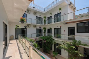 A multi-level building with balconies, air conditioning units, and potted plants. - Hotel Fusión (Santa Maria Colotepec)