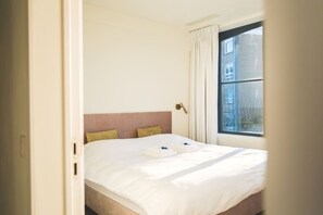 Une chambre d’hôtel avec un lit, une fenêtre et une porte.