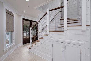 A staircase with wooden steps and metal railings, leading to a landing with white cabinets.