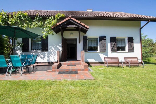 A house with a tiled roof, a front porch with steps, and a green lawn. - Holiday Villa With Private Garden, Lubiatowo (Choczewo)