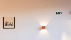 Un escalier avec une rampe, une applique murale et un tableau encadré.