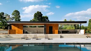 A modern outdoor pool area with lounge chairs and a covered seating area. - The Perch | Poolside Modern Mountain Retreat (Young Harris)