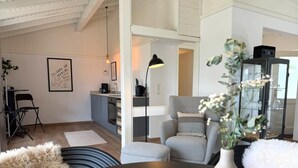 Een moderne woonkamer met een eettafel, grijze fauteuils, een zwarte lamp en een vaas met bloemen.