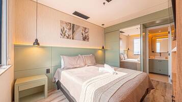 A modern bedroom with a large bed, bedside tables, a mirror, and a walk-in closet.