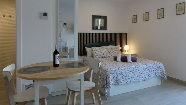 Ein Schlafzimmer mit Bett, Nachttisch und einem kleinen Tisch mit Stühlen.