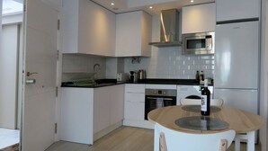 Eine moderne Küche mit weißen Schränken, einer Edelstahl-Mikrowelle und einem eingebauten Backofen.