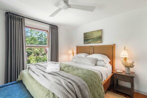 A bedroom with a bed, a nightstand, a lamp, a window with curtains, a ceiling fan, and a painting on the wall. - 1 Mile to Campground Beach, Dog Friendly, AC! (Eastham)
