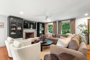 A living room with a fireplace, a sofa set, a coffee table, and a cabinet. - 1 Mile to Campground Beach, Dog Friendly, AC! (Eastham)