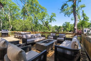 An outdoor deck with furniture, a grill, and a view of trees and a house. - 1 Mile to Campground Beach, Dog Friendly, AC! (Eastham)