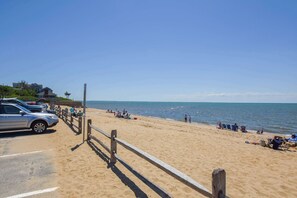 A beach with a wooden fence, parked cars, and people relaxing. - 1 Mile to Campground Beach, Dog Friendly, AC! (Eastham)