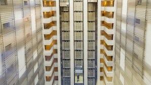 Ein Hochhaus mit mehreren Balkonen und einem zentralen Aufzugsschacht.
