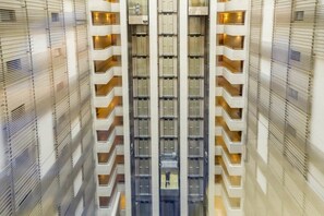 A high-rise building with multiple balconies and a central elevator shaft. - Manquehue Double EXC | Beautiful 2BR in Las Condes (Santiago)