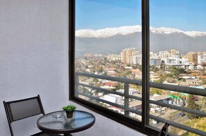 Ein Balkon mit Blick auf eine Stadtlandschaft und schneebedeckte Berge.