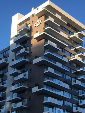 Ein mehrstöckiges Gebäude mit modernem architektonischen Design, mit Balkonen auf jeder Etage.