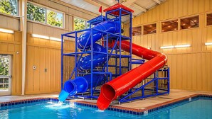 An indoor pool with a multi-level water slide structure.