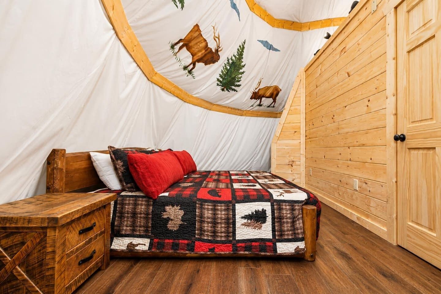 A cozy room with a bed, a wooden bench, and a wardrobe.