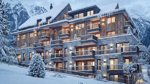 A multi-story lodge with stone facade, balconies, and large windows, surrounded by snow-covered mountains. - Modern Studio Near ski Resort (Ladis)