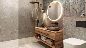 A modern bathroom with a stone wall, a wooden vanity, two round mirrors, and a white toilet. - Modern Studio Near ski Resort (Ladis)