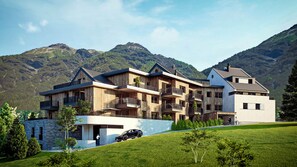 A multi-story hotel with balconies, a stone facade, and a view of mountains. - Modern Studio Near ski Resort (Ladis)