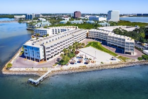 Ein Küstenhotel mit mehreren Gebäuden, einem Parkplatz und Blick auf den Strand.