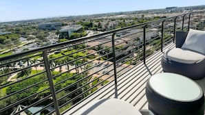Ein Balkon mit Sitzgelegenheit und Blick auf die Stadt.