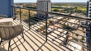 Un balcon offrant une vue sur le paysage urbain, avec des bâtiments et un parc.