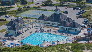 Ein Luftbild eines Resorts mit großem Schwimmbad, Tennisplätzen und einem Parkplatz.