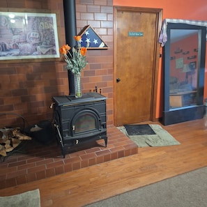 Una habitación con chimenea de ladrillo, una puerta con la leyenda 'The Dark Horse Suite' y un cuadro enmarcado en la pared.