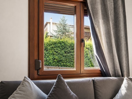 A room with a window, a sofa, and a curtain.. Bright and central apartment