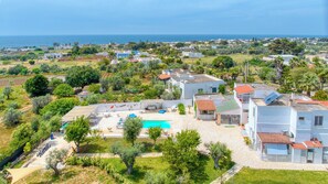 A residential area with a swimming pool, white buildings, and a view of the sea. - Suite Rilú con Idromassaggio -SalentoReservation (Capilungo)