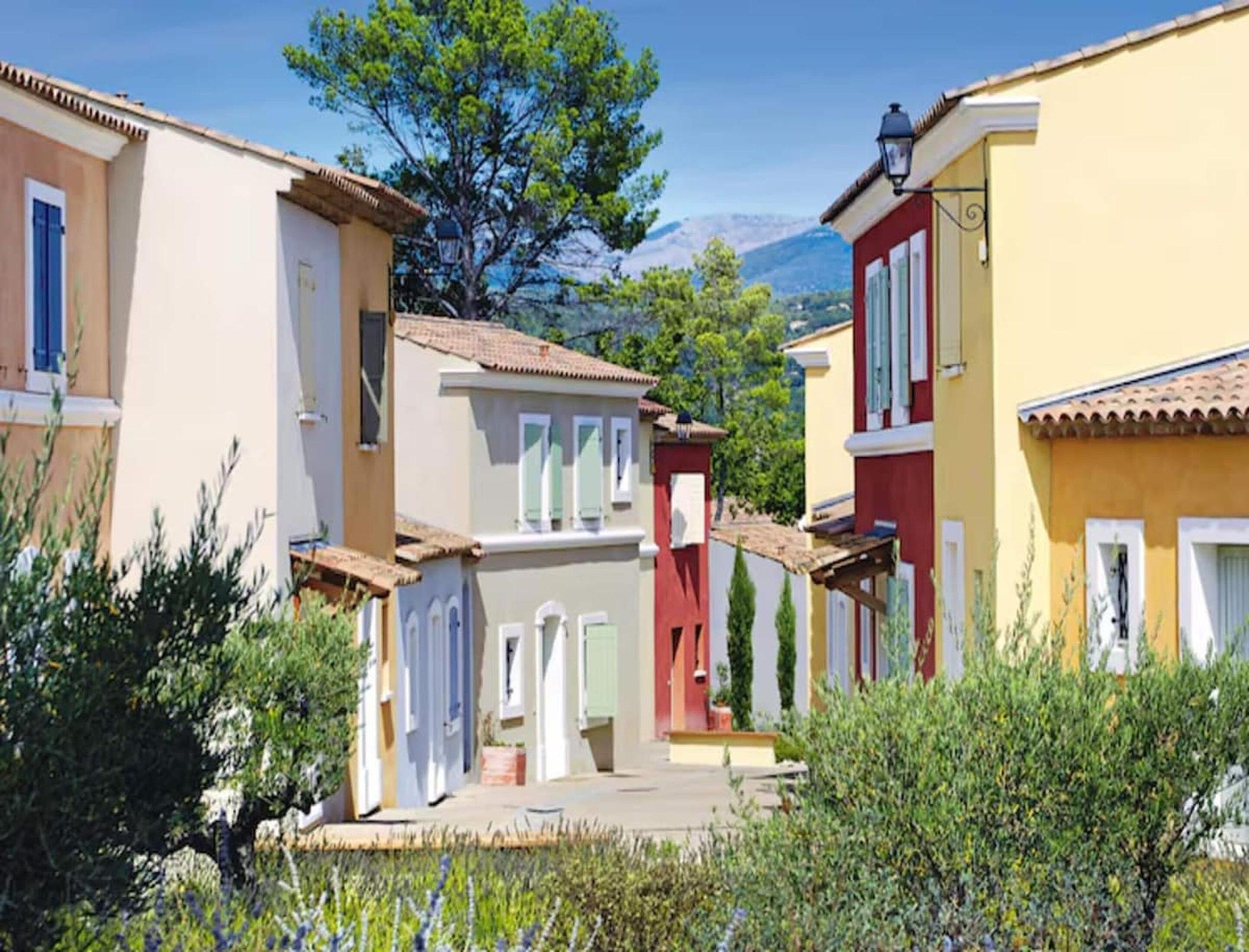 Une rangée de bâtiments aux couleurs vives, avec une montagne en arrière-plan.