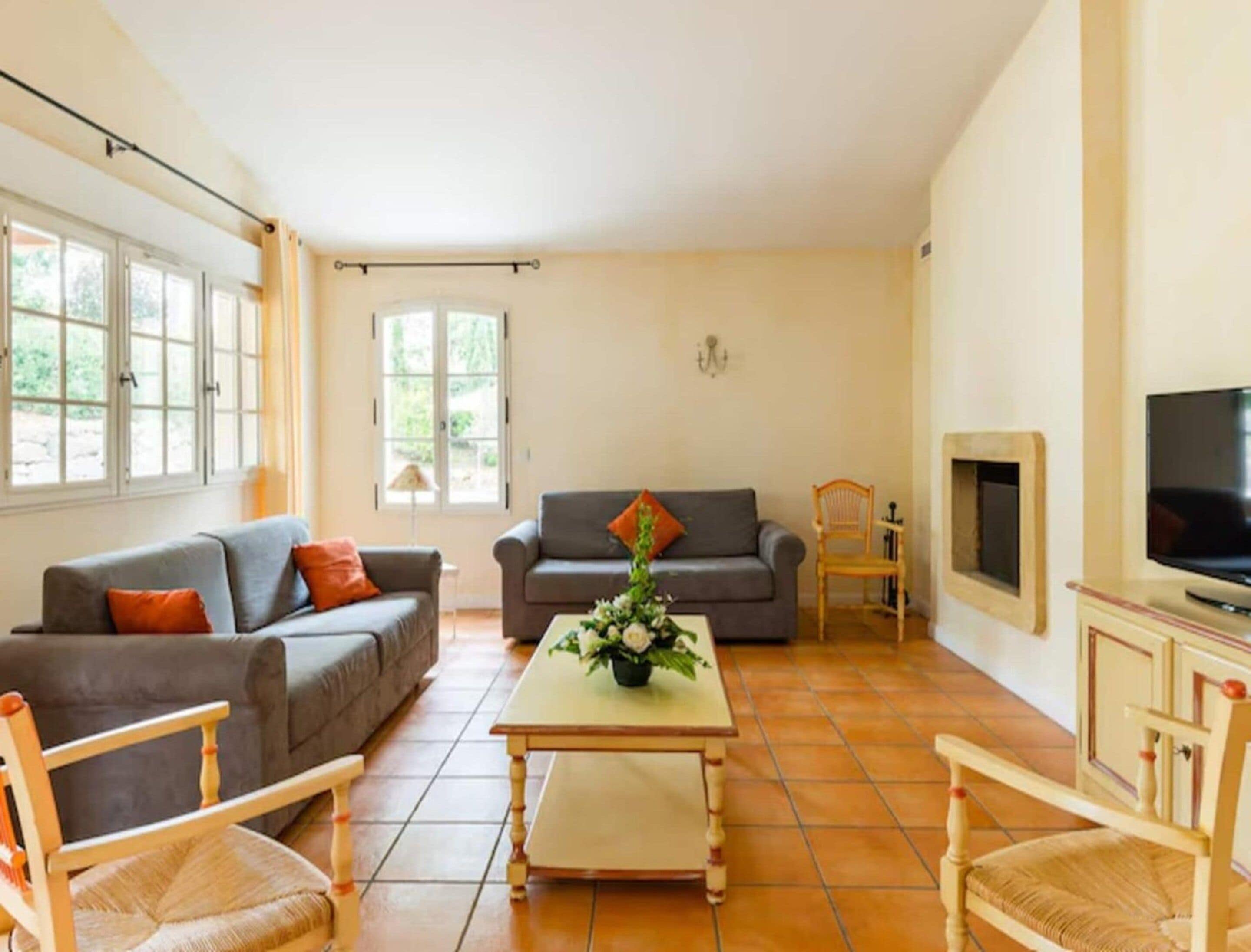 A living room with two sofas, a coffee table, a television, and a fireplace.