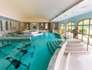 An indoor swimming pool with clear water, steps leading into the pool, and a view of greenery outside. - Fayence Provencal House for 4 (Fayence)