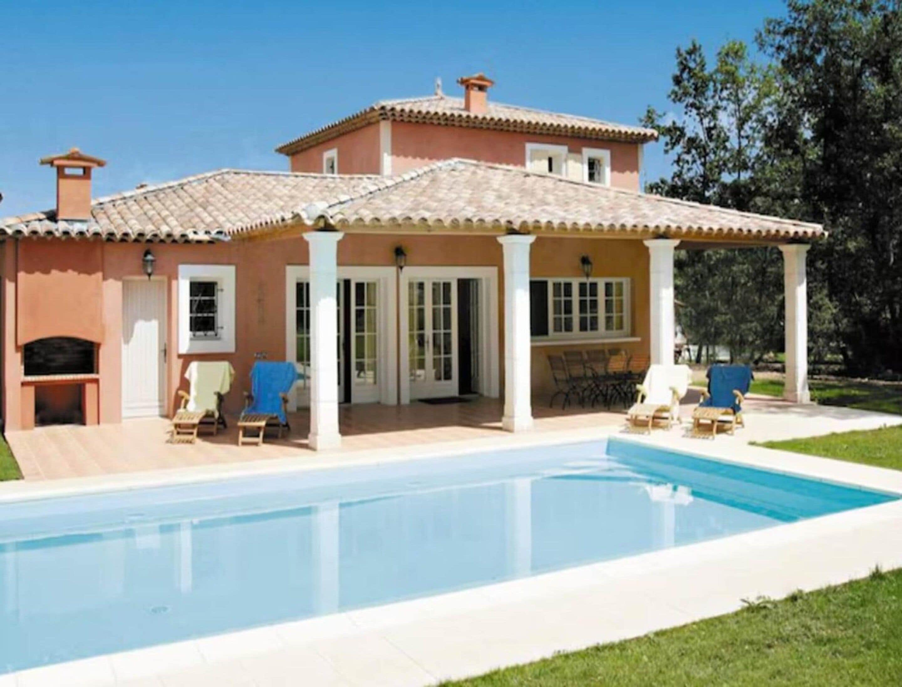 Une maison à deux étages dotée d’une piscine, d’un espace extérieur aménagé et d’un patio couvert.