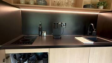 Cafetera o tetera, frigorífico, microondas y placa de cocina