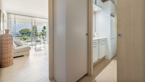 A modern apartment with a balcony, a sofa, and a kitchen area.