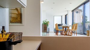 A modern kitchen with a dining area, large windows, and a view of the outdoors. - Suite Onda Reale - Acireale (Acireale)