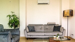 A living room with a grey sofa, a glass coffee table, a floor lamp, and a potted plant. - Suite Onda Reale - Acireale (Acireale)