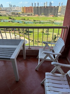 A balcony with a view of a golf course and buildings.