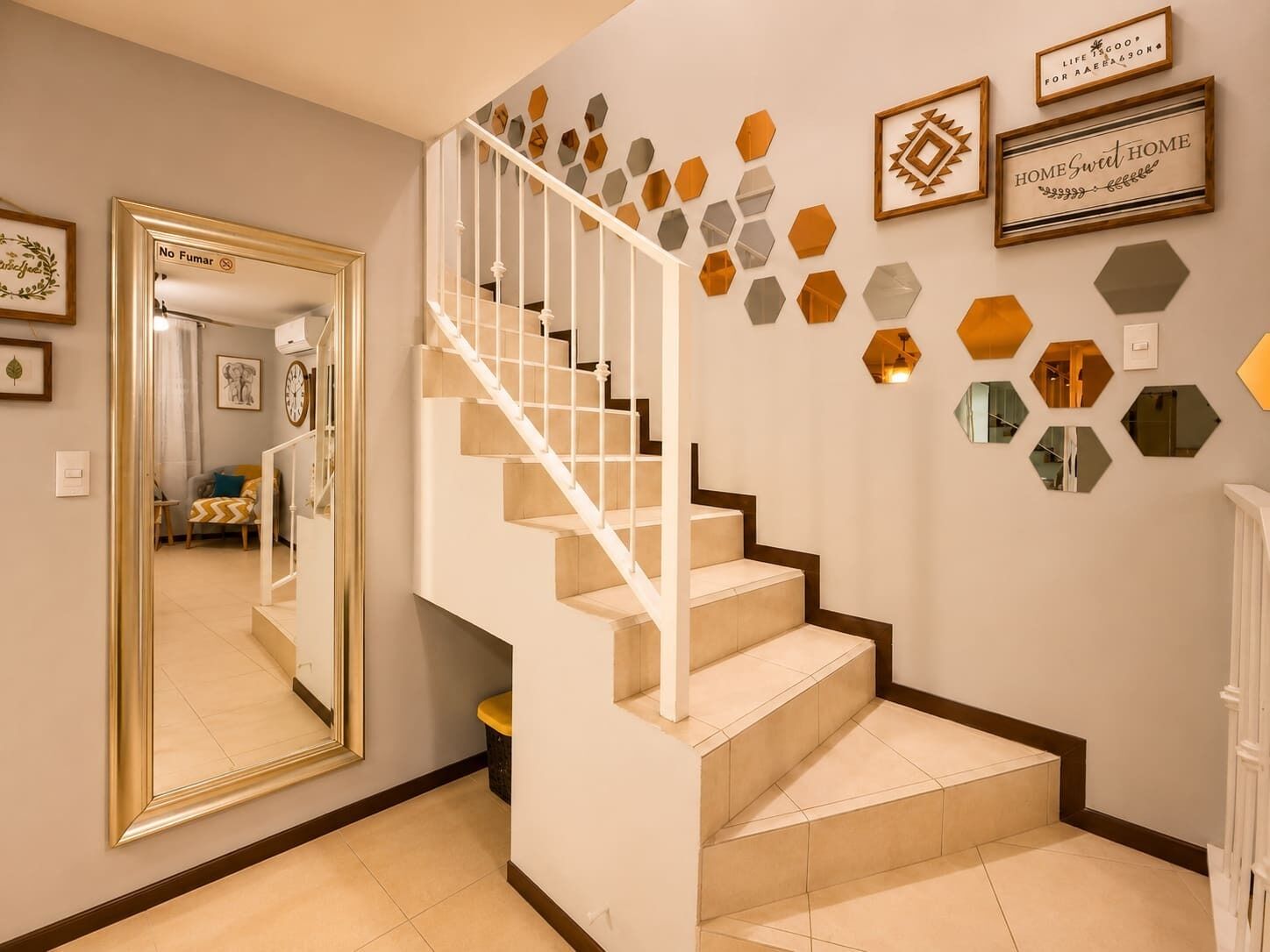 Un escalier avec une rampe blanche et des marches de couleur beige, menant à un palier.