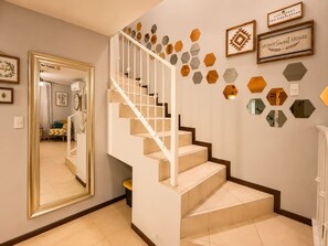 Una escalera con barandilla blanca y peldaños color beige, que conduce a una plataforma.