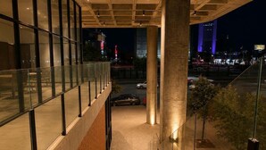 A modern building with a glass facade, a staircase, and a view of the city at night. - Maravilloso Apt 7px Frente arena Mty (Monterrey)