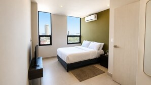 A modern bedroom with a bed, a TV, a window, and an air conditioning unit. - Fundidora Loft w/Parking & AC, Near Arena (Monterrey)