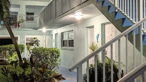 Un edificio de varios niveles con escaleras, plantas en el exterior y un cielo despejado.