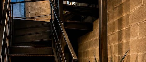 A staircase with metal railings, a 'HOME' doormat, and potted plants.