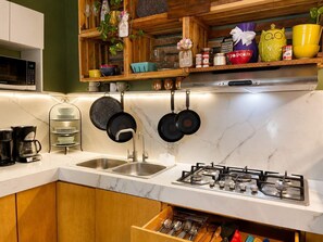 A kitchen with a gas stove, a microwave, and a sink. - 112-02-Hermoso Apartamento/10px/Ac/Wifi (Monterrey)