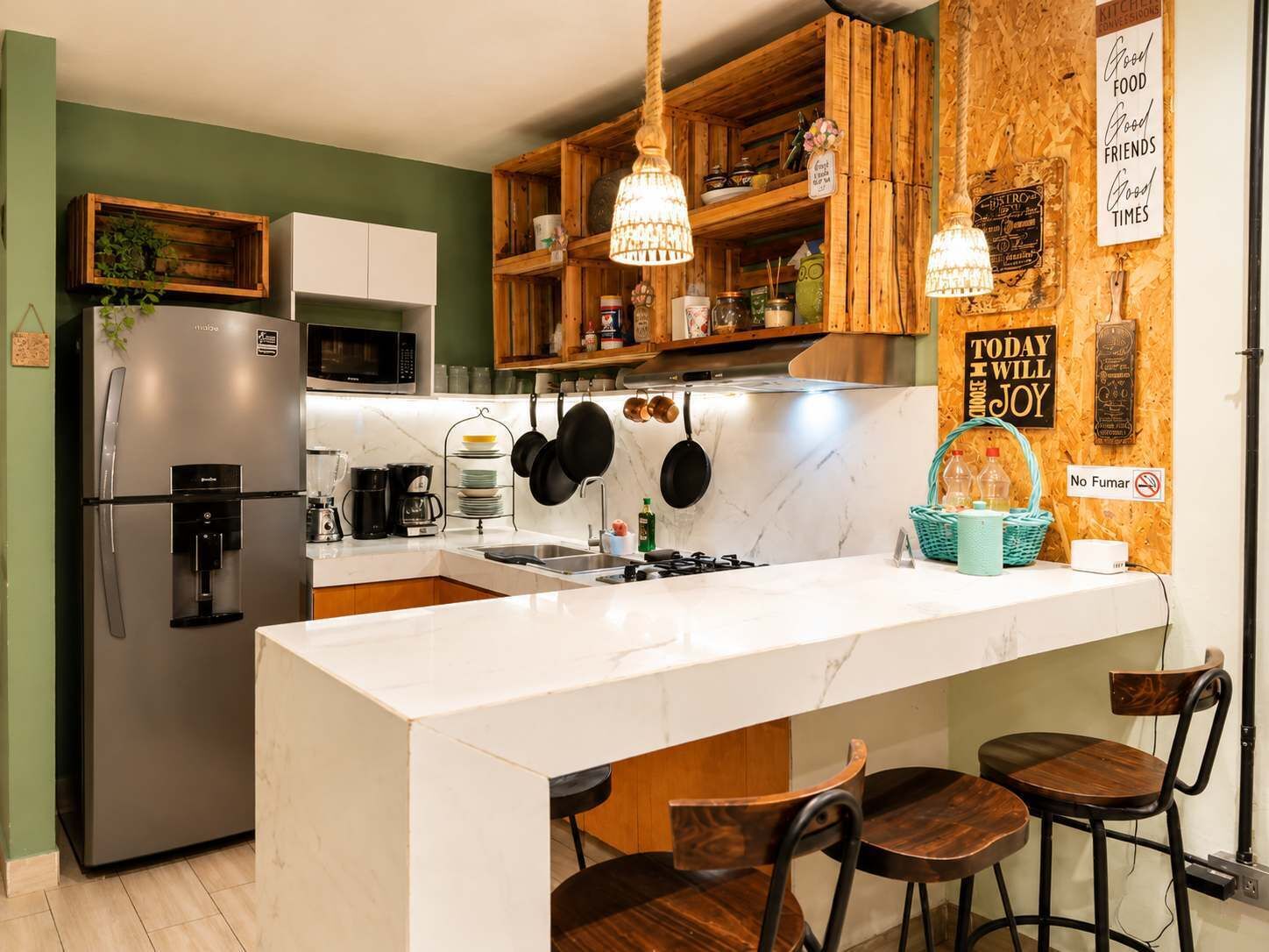 A modern kitchen with a central island, wooden cabinets, and hanging pots.
