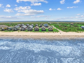 A coastal property with beachfront houses, a sandy beach, and a view of the ocean. - Beachfront with Hot Tub & Putt Putt | Sleeps 16 (Gilchrist)