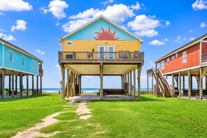 A beachfront house with a balcony, wooden deck, and a clear view of the ocean. - Beachfront with Hot Tub & Putt Putt | Sleeps 16 (Gilchrist)