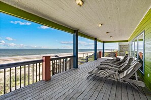 A wooden deck with lounge chairs overlooking a beach. - Beachfront 5BR | Gulf Views + Game Room with Pool Table (Port Bolivar)